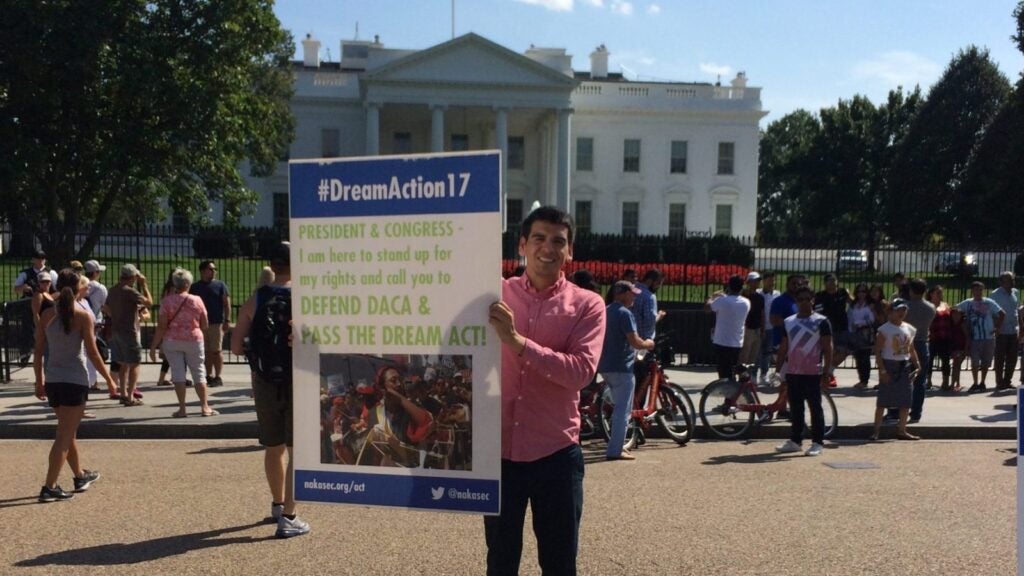 A picture of Abel Cruz Flores holding a placard supporting the Deferred Action for Childhood Arrivals (DACA) and the Dream Act.