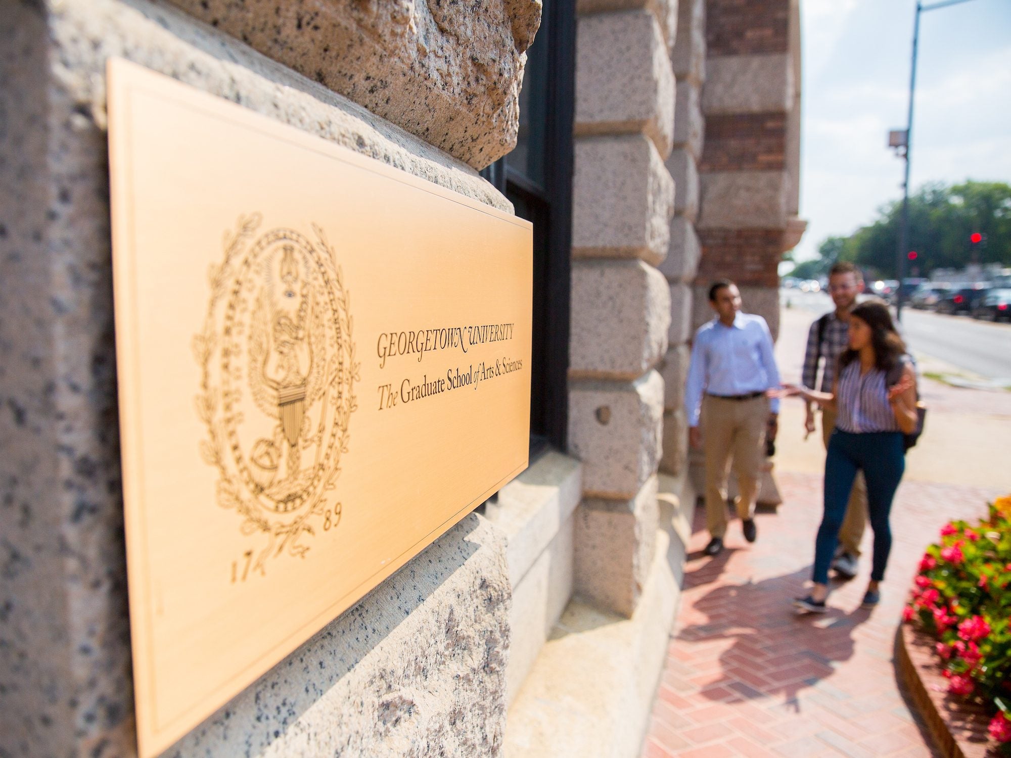 three students walking into the Grad School building
